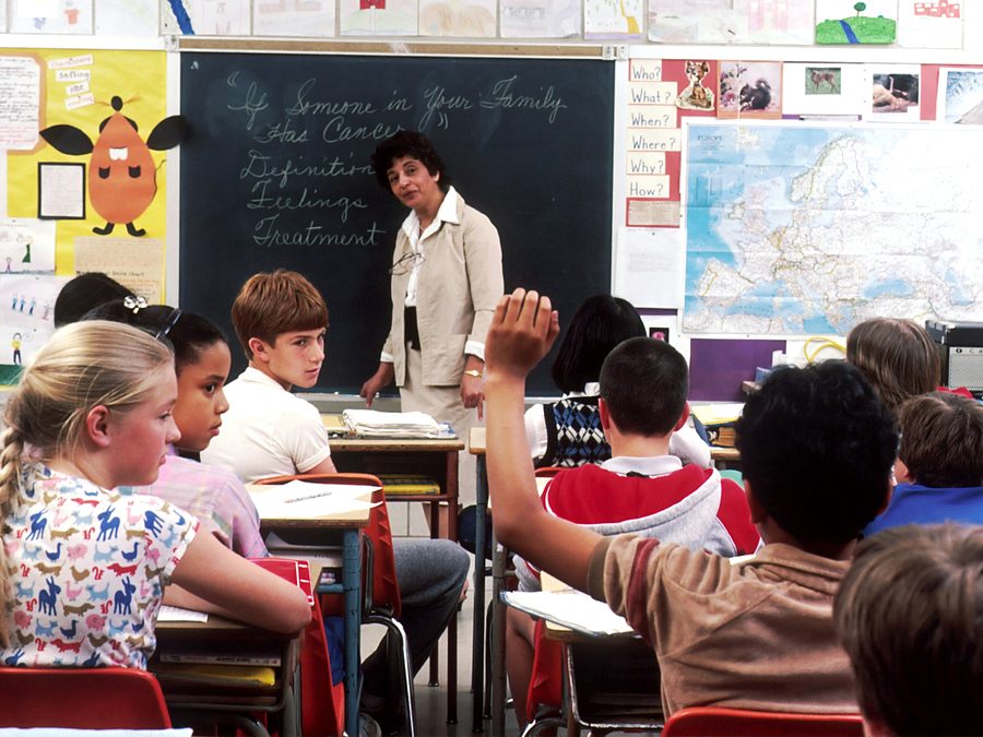 Students raising their hands in a classroom