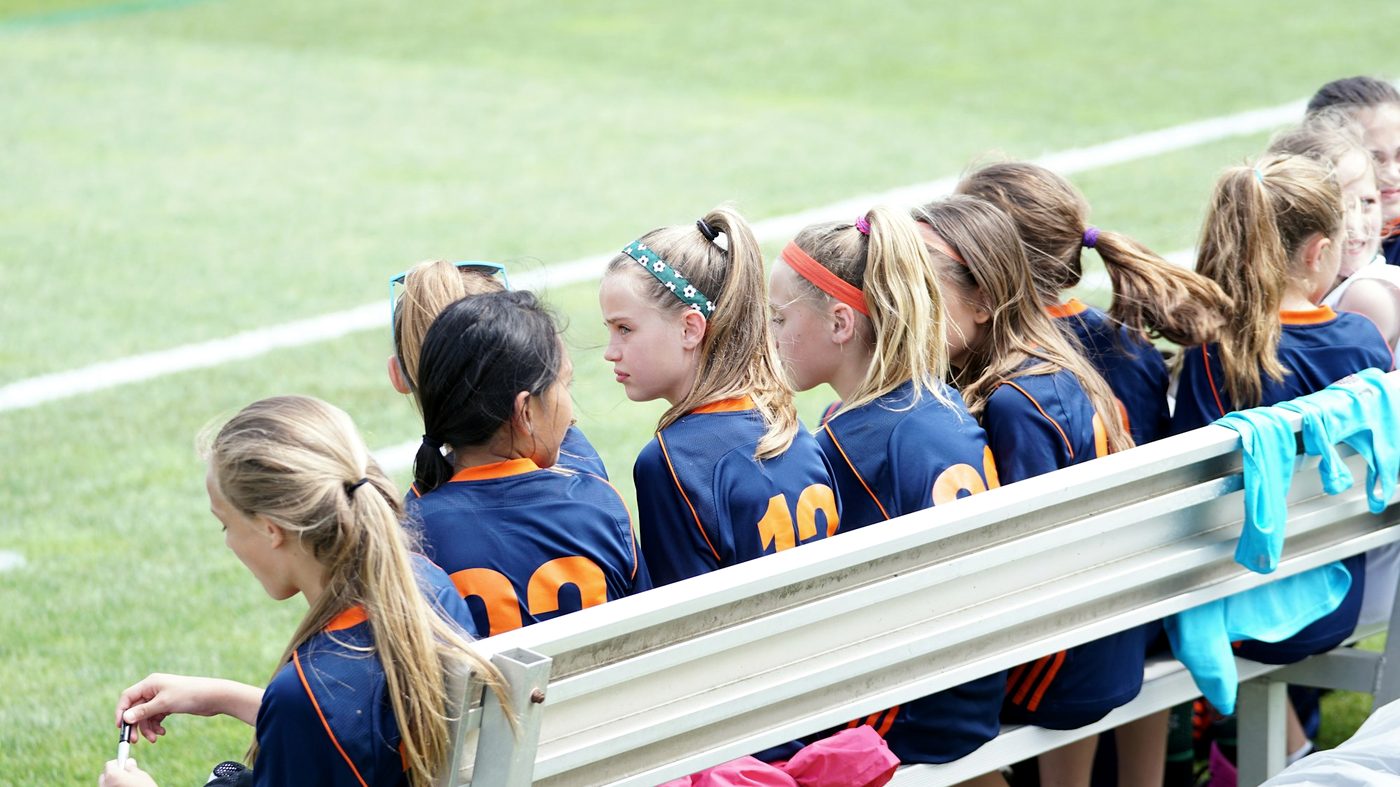 Young soccer players sitting together on the team bench