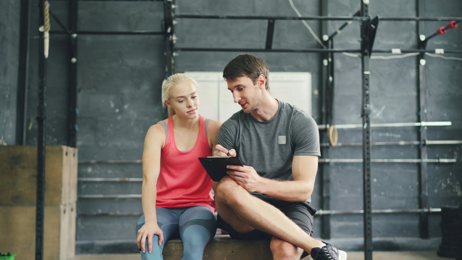 Coach reviewing a tablet with an athlete in a training gym